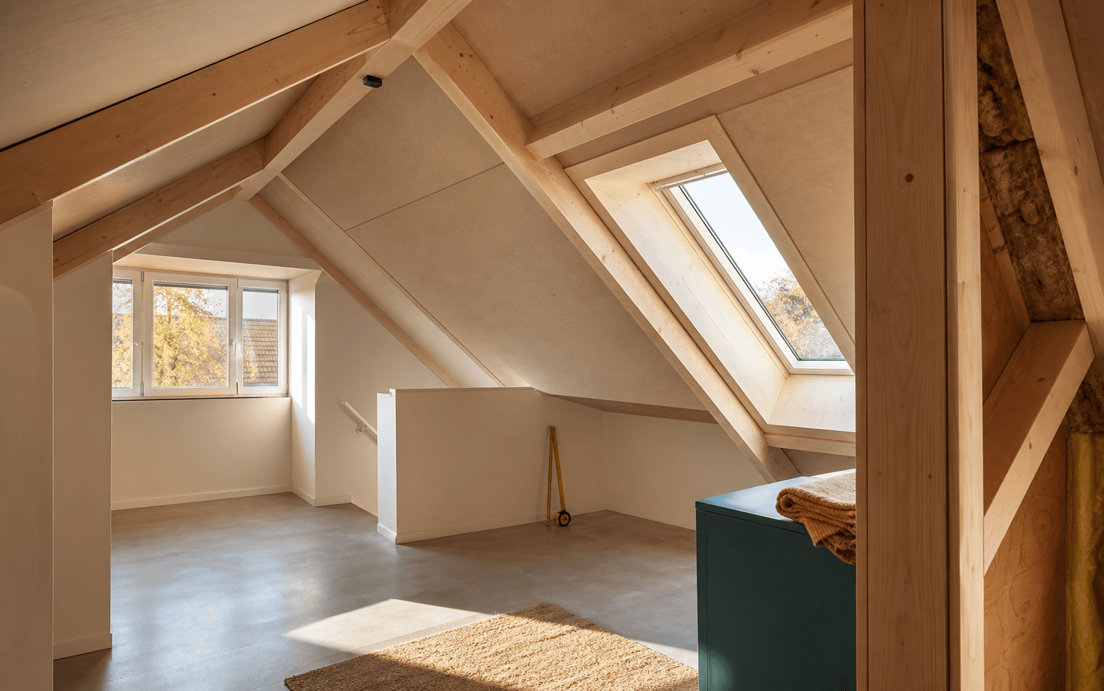 Lichte zolderruimte met houten balken als mogelijke overruimte